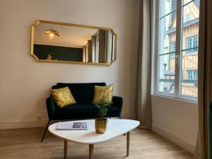 a living room with a couch and a mirror at Studio N°2 Plein coeur de Rouen in Rouen