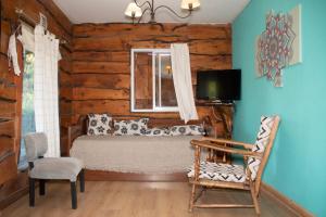 a bedroom in a log cabin with a bed and a television at Cabañas El Viejo Sauce in Tandil