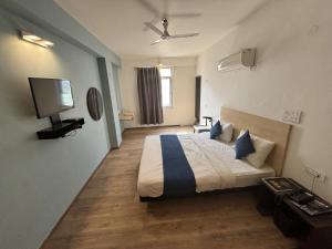 a bedroom with a bed and a flat screen tv at Hotel Luxurs a unit of knights in Jaipur