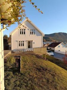 a white house sitting on top of a hill at Bellahuset - Charming House in Ulsteinvik in Ulsteinvik