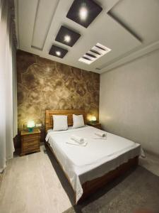 sypialnia z dużym łóżkiem i kamienną ścianą w obiekcie Abrid Surf w mieście Tamraght Ouzdar
