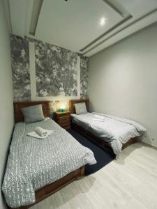 sypialnia z 2 łóżkami i szafką nocną z w obiekcie Abrid Surf w mieście Tamraght Ouzdar