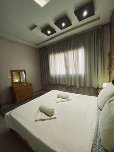 sypialnia z dużym łóżkiem z dwoma ręcznikami w obiekcie Abrid Surf w mieście Tamraght Ouzdar