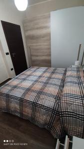 B&B Vista Mare في بالمي: غرفة نوم مع سرير وبطانية منقوشة