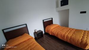 B&B Vista Mare في بالمي: سريرين مع أغطية برتقالية في الغرفة