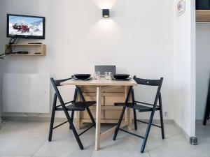 a table with two chairs and a laptop on it at Appartement Val Thorens, 2 pièces, 4 personnes - FR-1-637-66 in Val Thorens