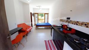 uma cozinha com um balcão e cadeiras vermelhas num quarto em Waimea FLATS Itamambuca em Ubatuba