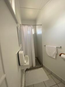 a white bathroom with a shower and a toilet at Civic Guesthouse in Townsville