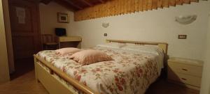 a bedroom with a bed with two pillows on it at Pizzeria Marmolada Camere in Sottoguda