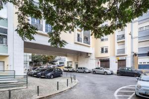 a parking lot with cars parked in front of a building at Akicity Santa Apolónia Green in Lisbon