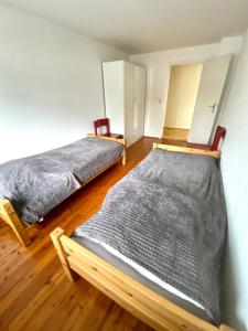 two beds in a room with wooden floors at Entire apartment in Eggenfelden in Eggenfelden