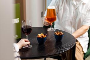 two people sitting at a table with two glasses of wine and snacks at Leonardo Hotel Inverness in Inverness