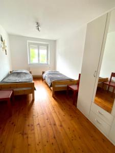 a bedroom with two beds and a wooden floor at Entire apartment in Eggenfelden in Eggenfelden