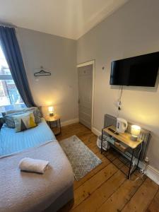 a bedroom with a bed and a flat screen tv at Rooms Anfield- 5 mins from LFC in Liverpool