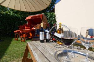 two glasses of wine sitting on a wooden table at Chambres & Table d'hôtes La Bordelaise in Cenon +14 photos