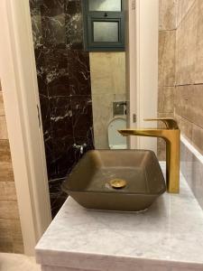 La salle de bains est pourvue d'un lavabo en bronze sur un comptoir. dans l'établissement شاليه ألو, à Al Bukayriyah