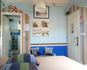 a bedroom with a bed and a blue wall at Chambres & Table d'hôtes La Bordelaise in Cenon