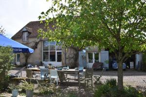 una mesa y sillas frente a una casa en Charmecamping Domaine Bleu Celeste, en Couleuvre