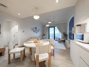 een keuken en een woonkamer met een tafel en stoelen bij Trophy - Mykonos-Inspired La Mer Suite in Dubai