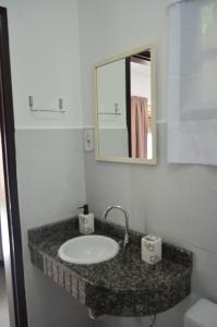 y baño con lavabo y espejo. en Pousada Ponta Das Pedras, en Morro de São Paulo