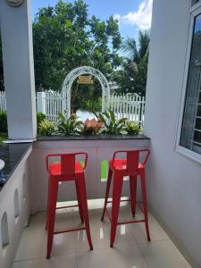 two red chairs sitting on a balcony with a window at Nha Trang Riverside Villa in Nha Trang