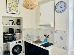 a kitchen with a sink and a clock on the wall at Hypercentre Studio Gambetta in Cahors