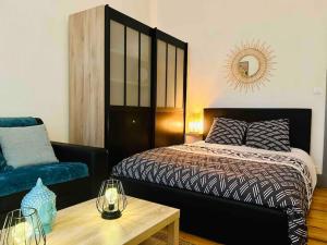 ein Schlafzimmer mit einem Bett, einem Sofa und einem Tisch in der Unterkunft Hypercentre Studio Gambetta in Cahors
