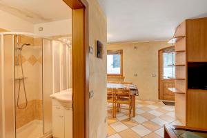 a bathroom with a shower and a dining room at Appartamento Piz Filone in Livigno