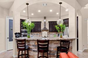 a kitchen with a large island with bar stools at Randolph Central Location, 1-story, Chef Kitchen, Creekside in Selma
