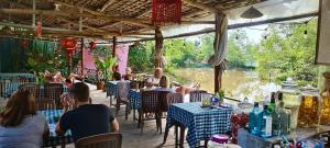 a group of people sitting at tables in a restaurant at Song Ngư Pisces Homestay in Can Tho