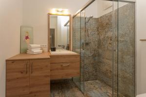 łazienka z prysznicem, umywalką i lustrem w obiekcie Appartement Schneider by Schladming-Appartements w Schladming