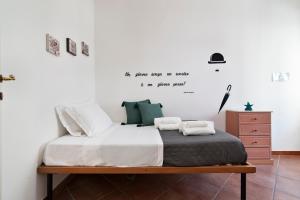 1 dormitorio con 1 cama con sábanas blancas y almohadas verdes en Le 2 Palme Family House - Lecce Selection, en Lecce