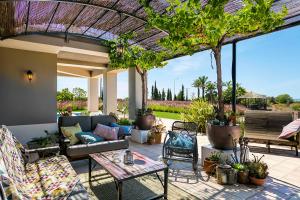 une terrasse avec un canapé, des tables et des arbres dans l'établissement Quinta dos Caneiros Luxury villa Ocean views walk to beach, à Ferragudo