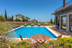 - une piscine dans une cour avec une maison dans l'établissement Quinta dos Caneiros Luxury villa Ocean views walk to beach, à Ferragudo