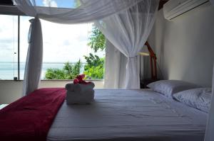 a bedroom with a bed with a view of the ocean at Pousada Ponta Das Pedras in Morro de São Paulo