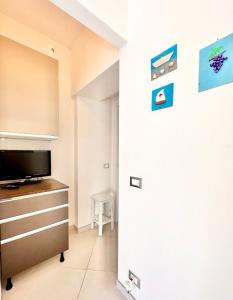 een woonkamer met een tv en een kast bij Hostdomus - Casa Arianna in Finale Ligure