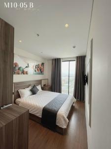 a bedroom with a bed and a large window at Penthouse Apec Phú Yên in Liên Trì (3)