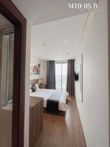a bedroom with a bed and a large window at Penthouse Apec Phú Yên in Liên Trì (3)