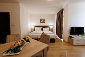 a hotel room with a bed and a table and a room at Green Wood Hotel & Spa Bansko in Bansko
