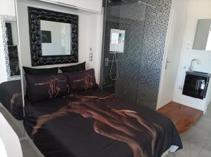 een slaapkamer met een bed met een hand erop bij Village Naturiste Studio Luxe in Cap d'Agde