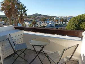 2 stoelen en een bureau op een balkon met uitzicht bij Village Naturiste Studio Luxe in Cap d'Agde