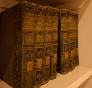 a row of books on a shelf in a museum at Old Coastguards - Stunning Historic Cottage in Totland