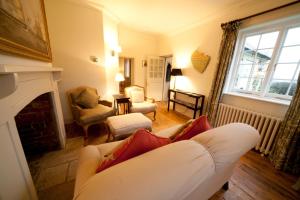 a living room with a white couch and a fireplace at Old Coastguards - Stunning Historic Cottage in Totland
