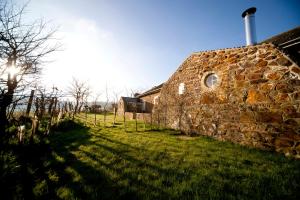 a stone building in a field with the sun behind it at Old Coastguards - Stunning Historic Cottage in Totland
