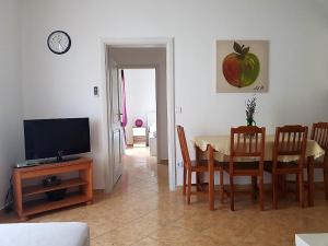 a living room with a dining room table and a television at Apartment Oasis - Novalja in Novalja