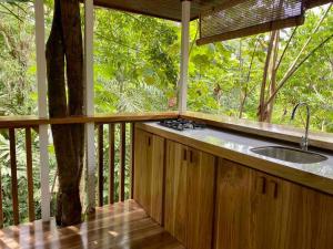 a kitchen with a sink on a porch with a tree at NEW Jungle Casita- Steps away from Punta Uva in Punta Uva