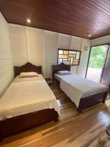 two beds in a room with wooden floors at NEW Jungle Casita- Steps away from Punta Uva in Punta Uva