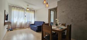 un soggiorno con tavolo e divano blu di Elegância Urbana, Apartamento Exclusivo, com ar a Maringá
