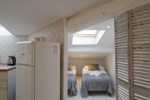 マントンにあるPied-a-terre Saint Michelのベッド1台、冷蔵庫が備わる小さな客室です。
