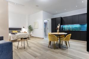 un salon avec un lit, une table et des chaises dans l'établissement Suite Deluxe Valencia - AIORA Apartments, à Valence